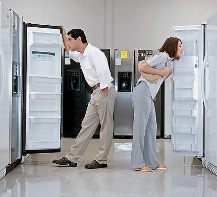 мужчина и женщина смотрят в холодильники